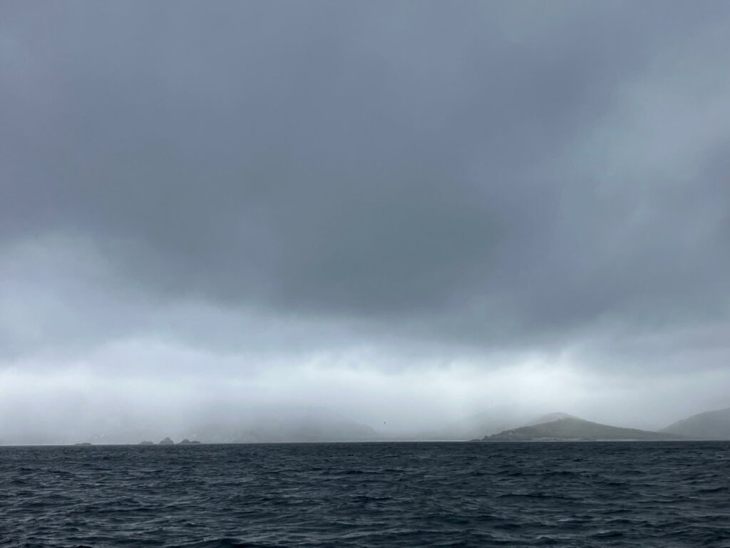 La côte Est de la péninsule Mitre dans la brume, vue depuis le détroit de Lemaire à bord du voilier Milagro